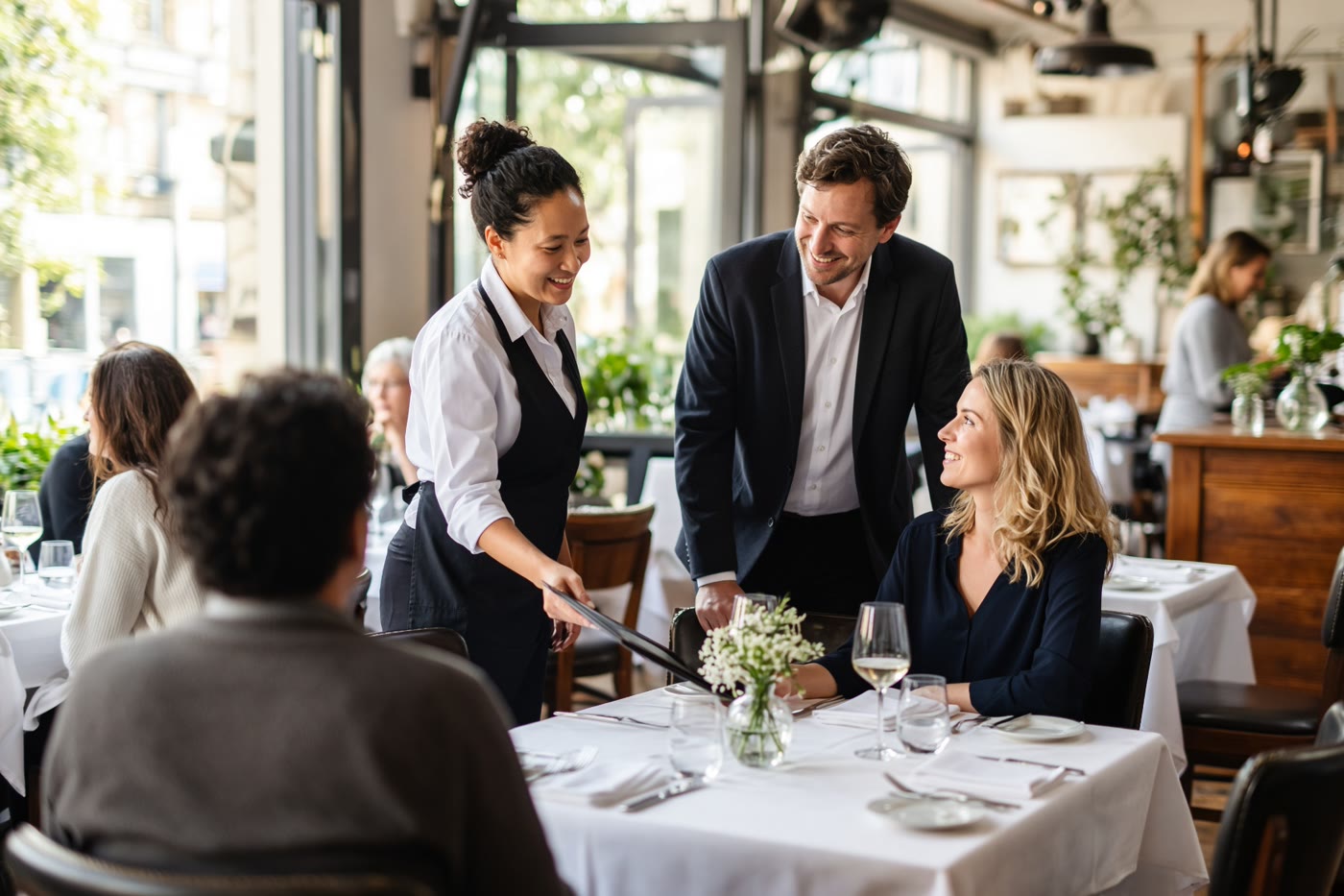 Restaurant staff seating guests in a busy dining room. Temporary photograph. Not a client, testimonial, or case result.